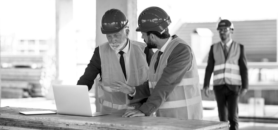 SINGLE-IMAGE_workers-at-construction-site-looking-at-laptop_jan25