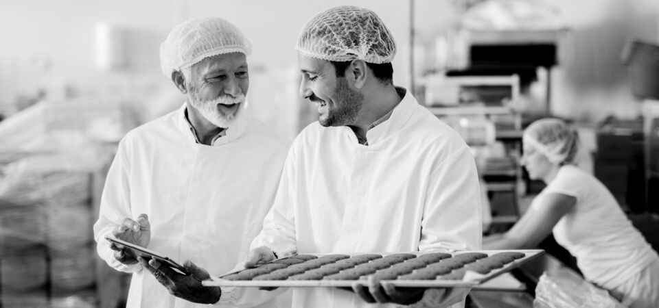 SINGLE-IMAGE_man-with-tablet-checking-tray-of-biscuits_nov23