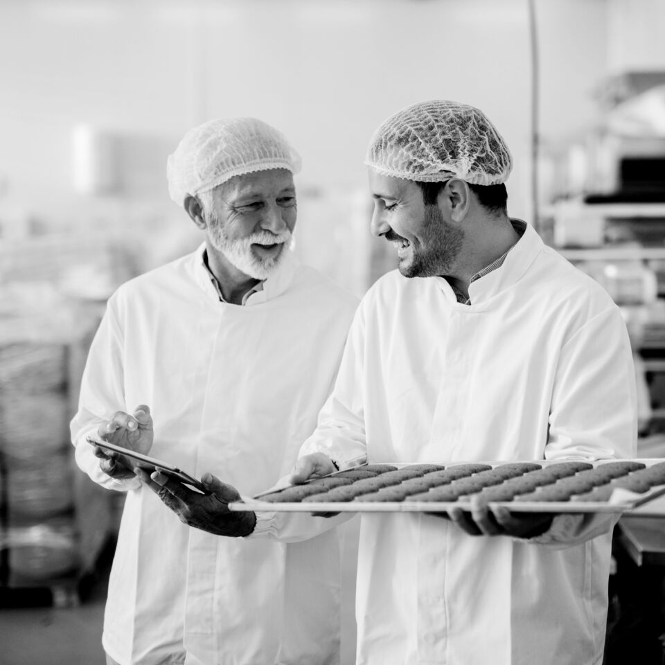 SINGLE-IMAGE_man-with-tablet-checking-tray-of-biscuits_nov23